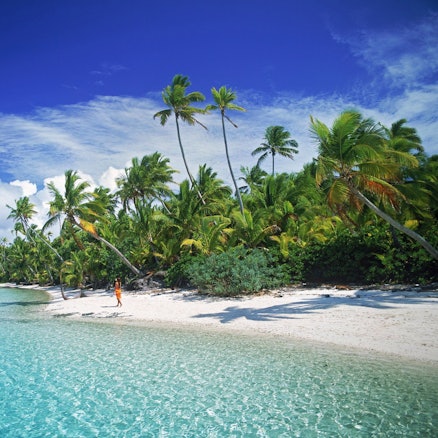 ARCHIV - Eine Frau geht am Sandstrand von Aitutaki, einer der Cook Inseln am Südpazifik.
