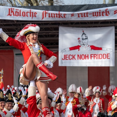 Tanzmariechen beim Funkenbiwak der Roten Funken am Neumarkt. Im Hintergrund ein Transparent „Jeck noh Fridde“ gegen den Krieg Russlands in der Ukraine.