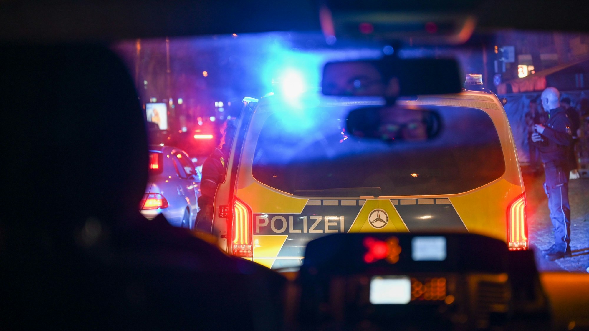 Ein Polizeiwagen von hinten im Dunkeln.