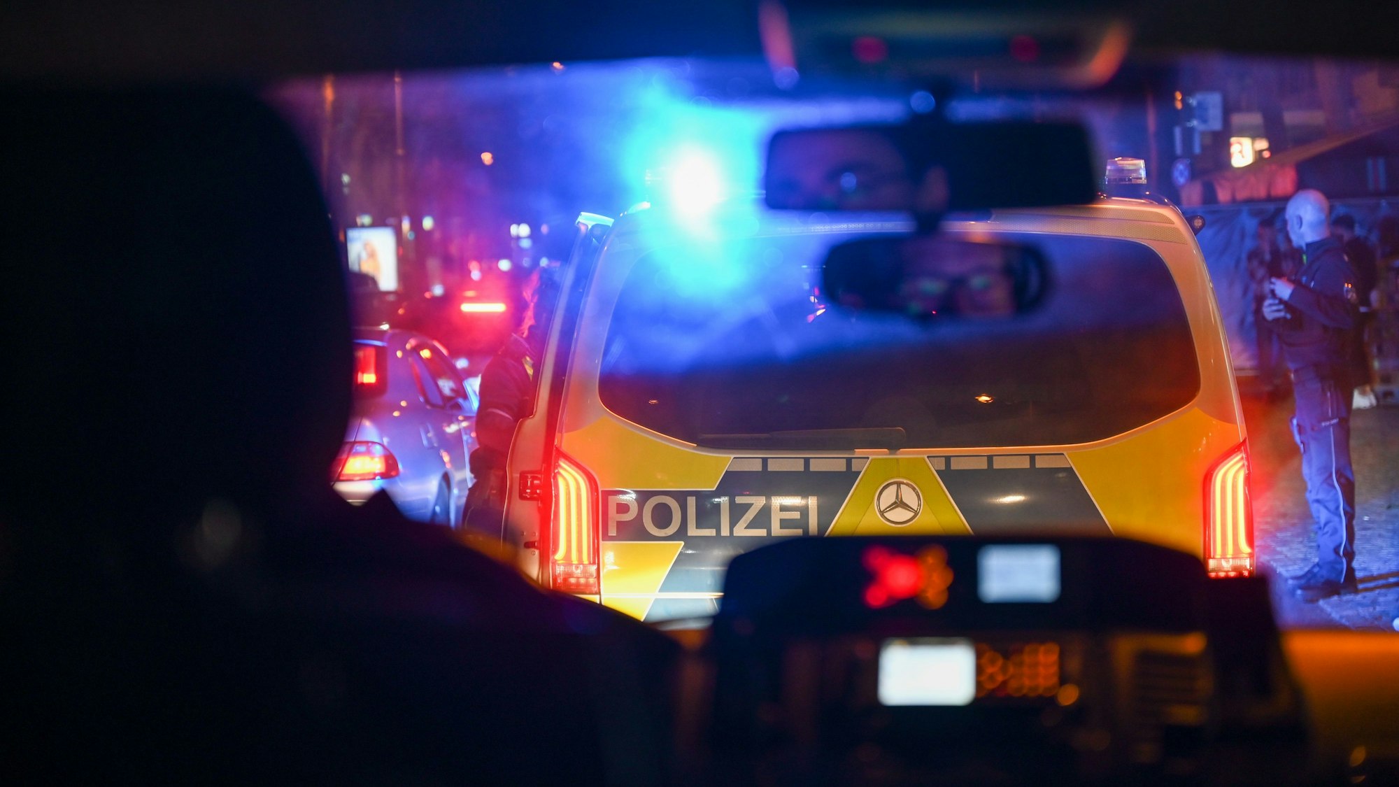 Ein Polizeiwagen bei Nacht mit Blaulicht.