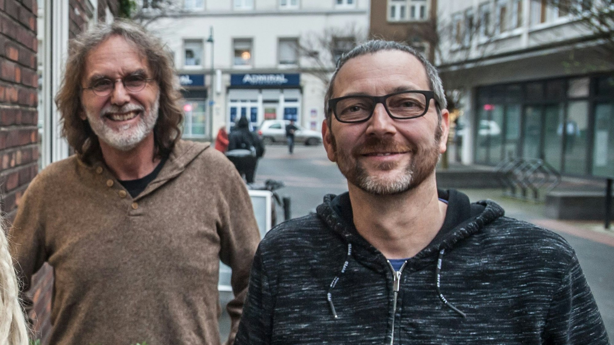 Zwei Männer stehen nebeneinander und lächeln in die Kamera.