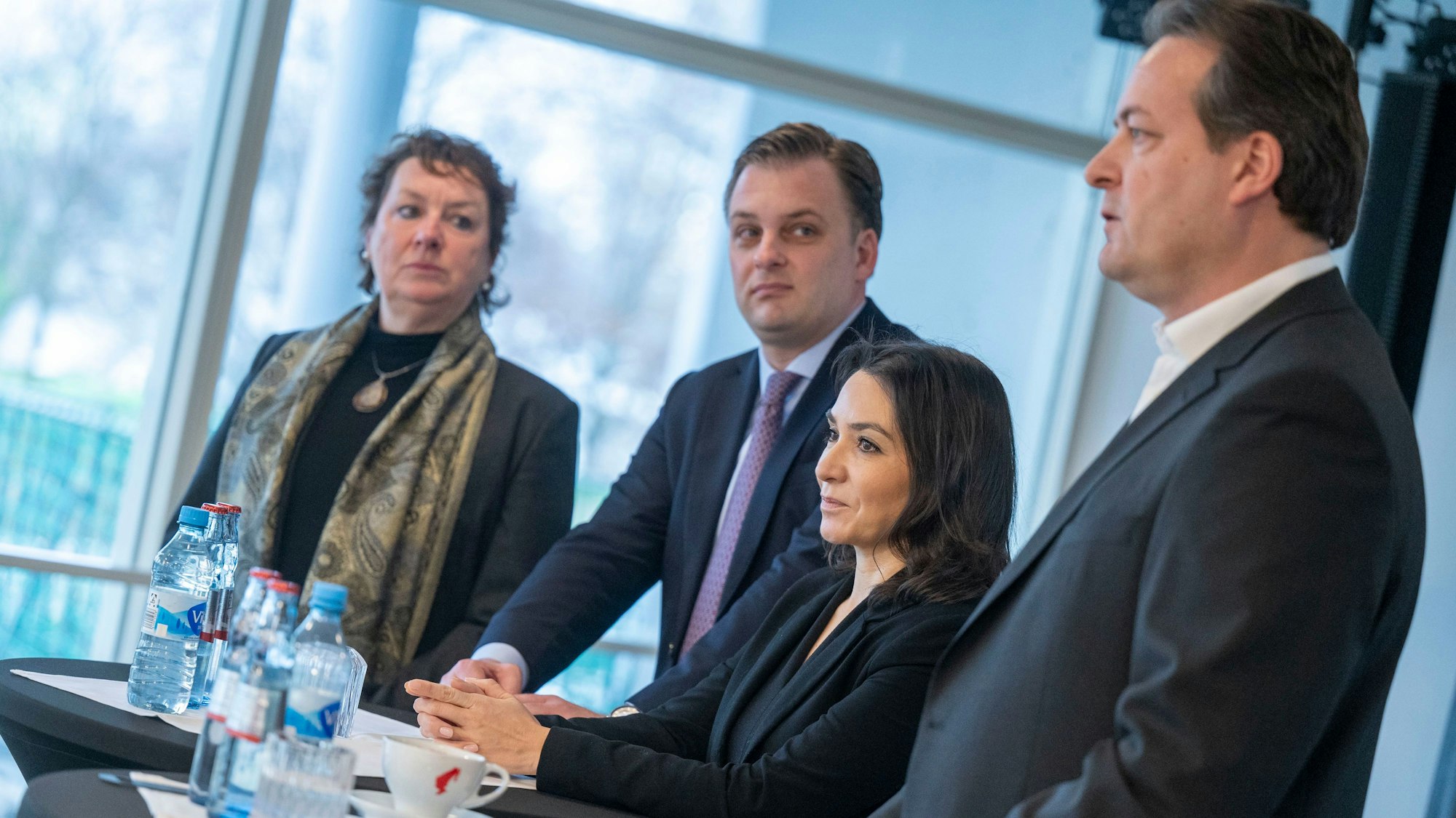 Das Bild zeigt zwei Männer und zwei Frauen im Kölner Rheinparkcafé. Das Quartett steht an zwei Stehtischen.