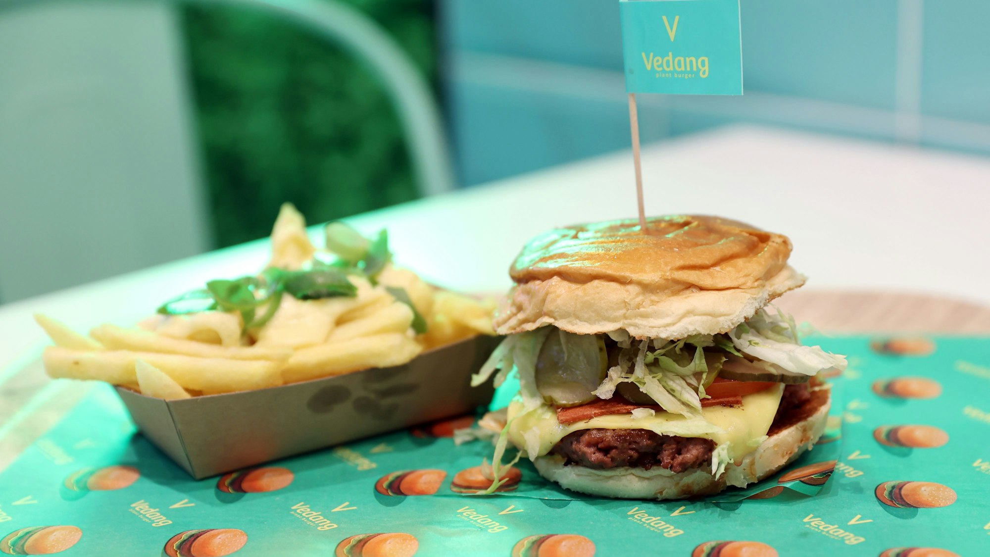 Der Beyond Burger und eine Portion Pommes mit Käse-Soße stehen auf einem Tablet.