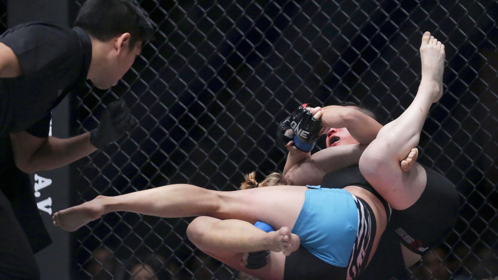 Zwei MMA-Kämpferinnen liegen ringend auf dem Boden.