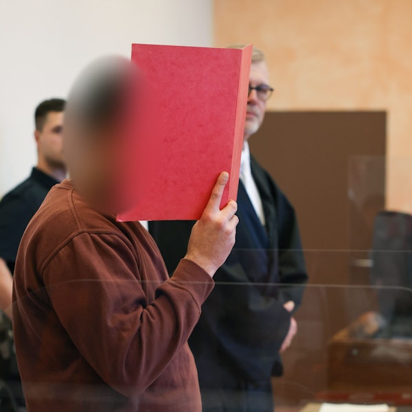 Der Angeklagte steht in einem Saal vom Landgericht. Der Kopf des Mannes ist auf dem Bild unkenntlich gemacht.