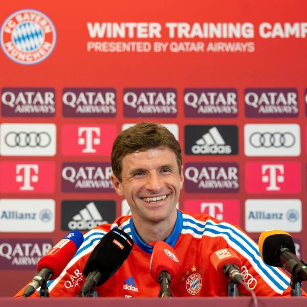 Thomas Müller lacht auf einer Pressekonferenz des FC Bayern München.