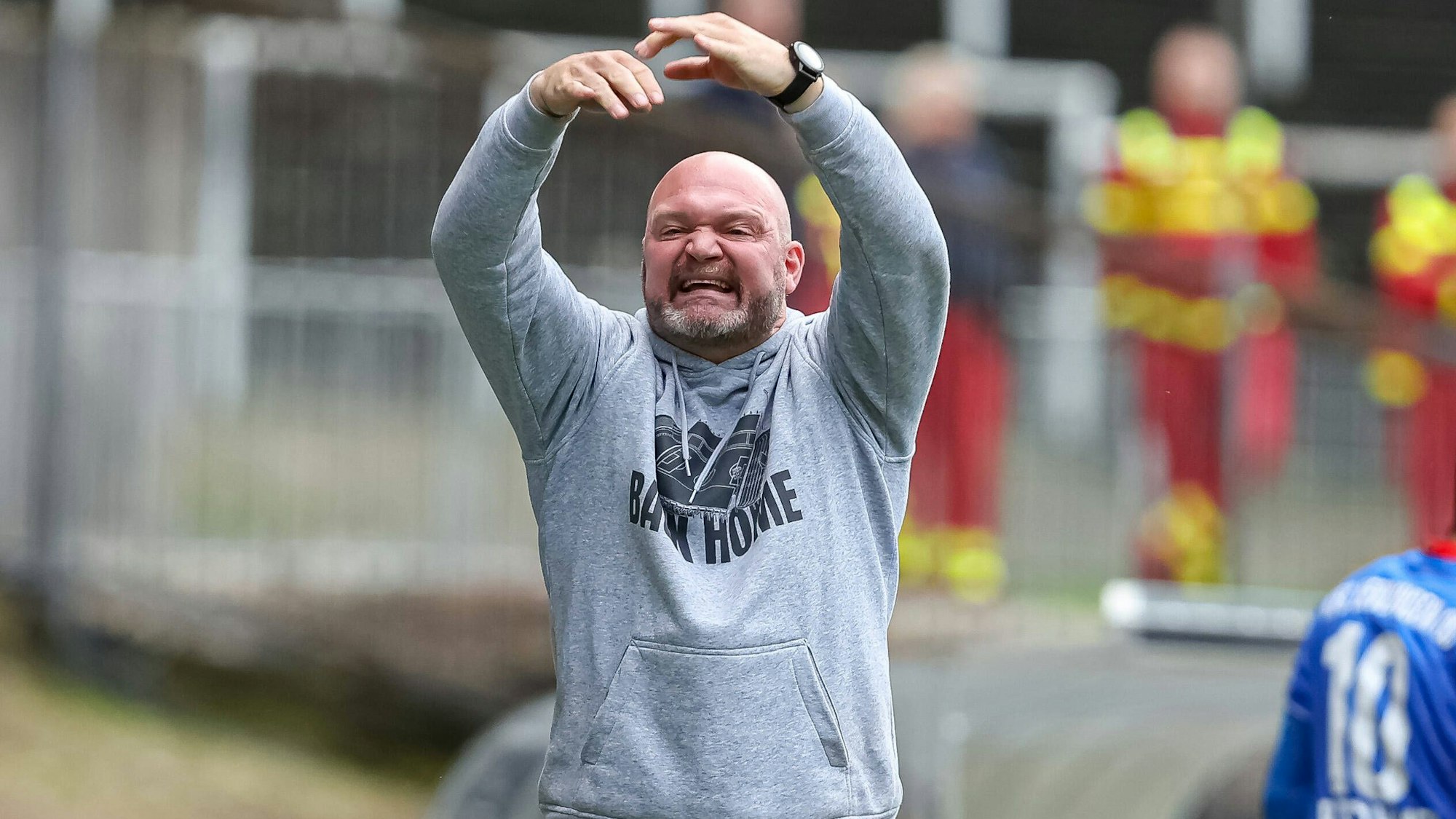 Trainer Alexander Voigt gestikuliert mit beiden Händen über dem Kopf und kündigt einen Wechsel an.