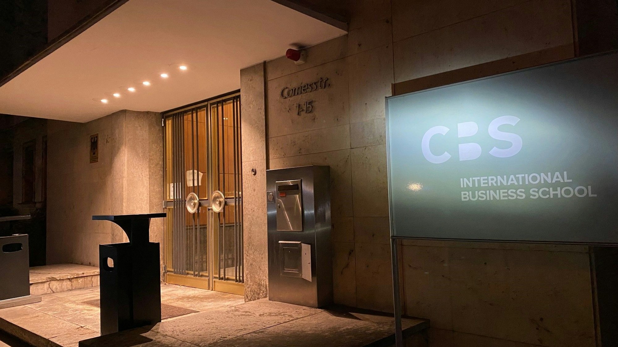 Der Eingangsbereich der privaten Hochschule CBS in Brühl ist im Dunkeln erleuchtet.
