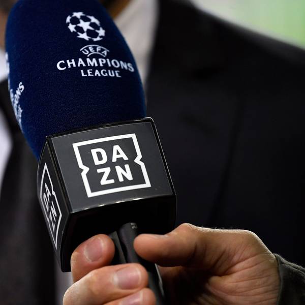 Ein Reporter hält ein Mikrofon des Streamingdienstes DAZN während eines Interviews fest. (Symbolbild)