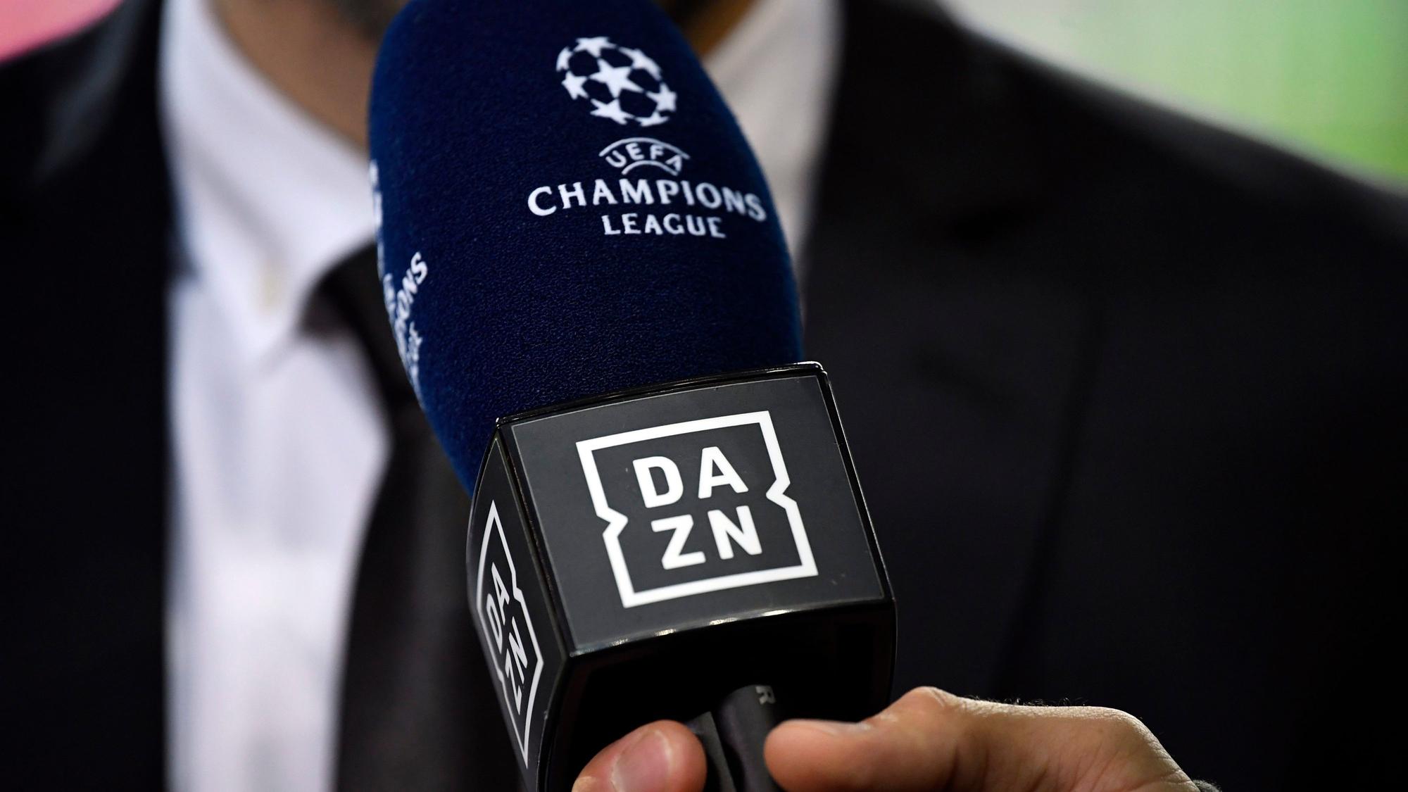 Ein Reporter hält ein Mikrofon des Streamingdienstes DAZN während eines Interviews fest. (Symbolbild)
