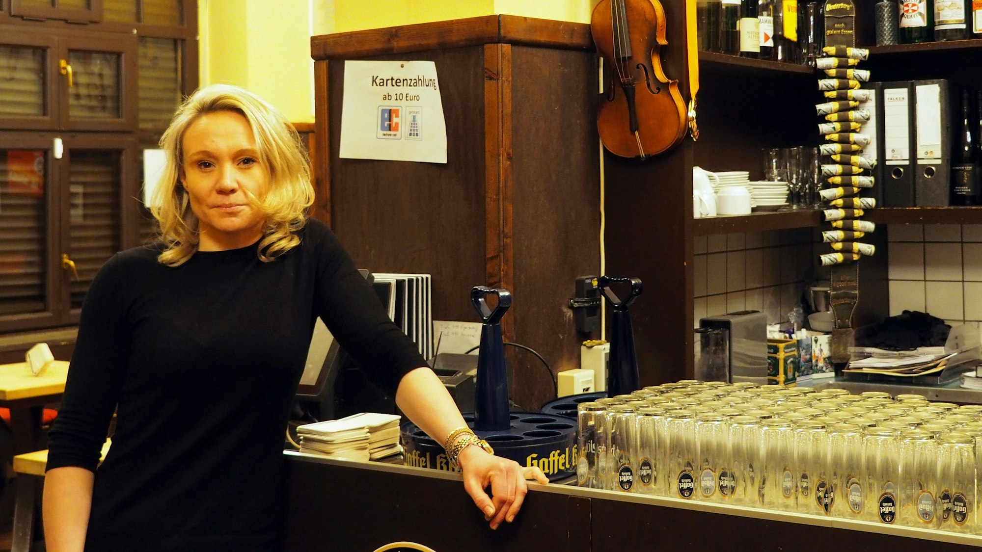Die Wirtin des Gasthaus Eule steht vor ihrer Theke – auf der Theke stehen viele Kölschgläser.