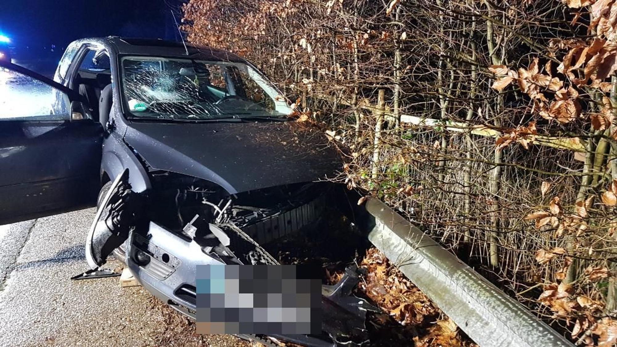 Ein schwer beschädigtes Auto steht an einer Leitplanke.