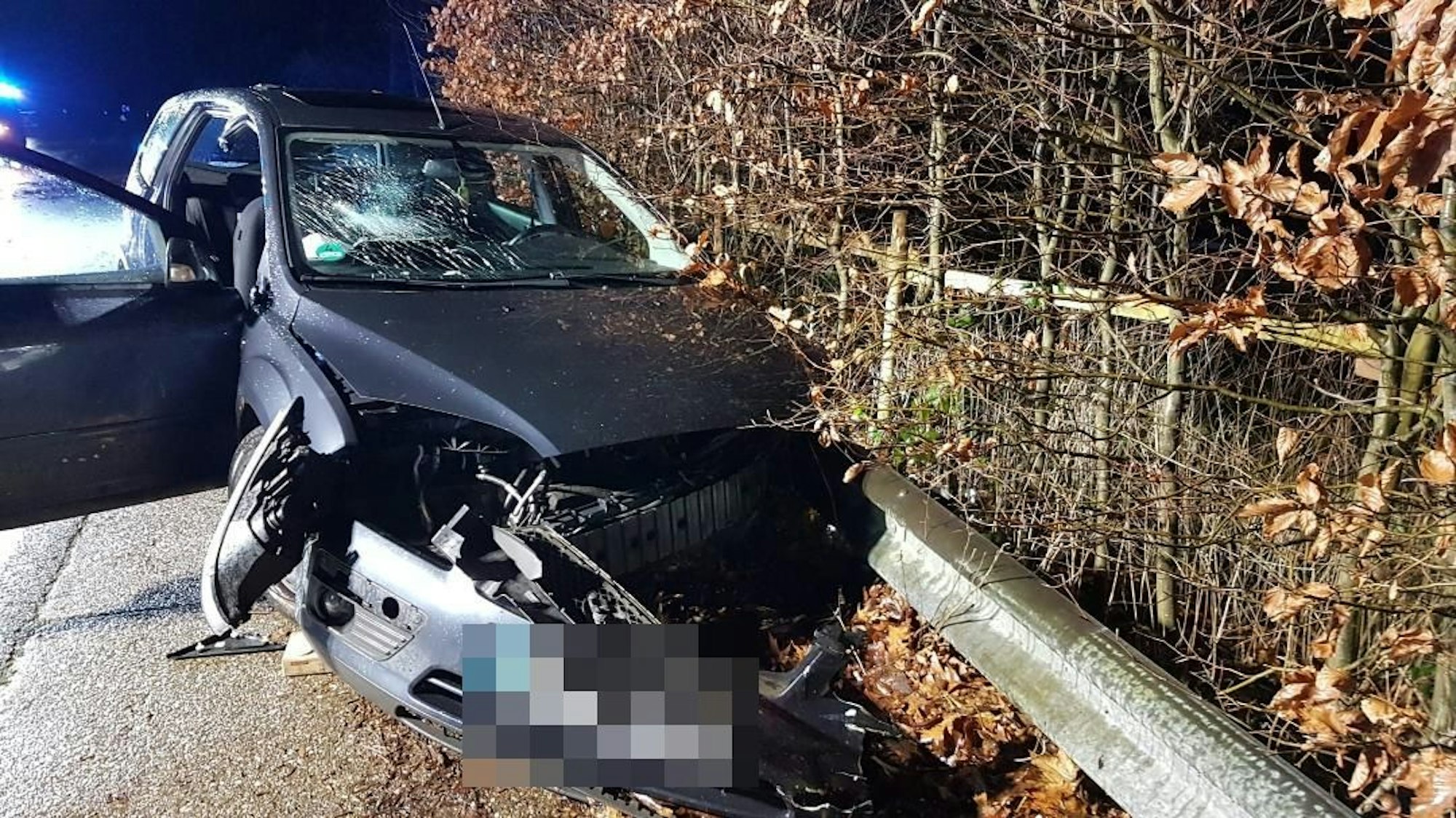 Ein schwer beschädigtes Auto steht an einer Leitplanke.