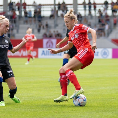 Fußballerin Merle Barth, im Trikot von Atlético Madrid, versucht einer Spielerin vom FC Bayern München, den Ball abzunehmen.
