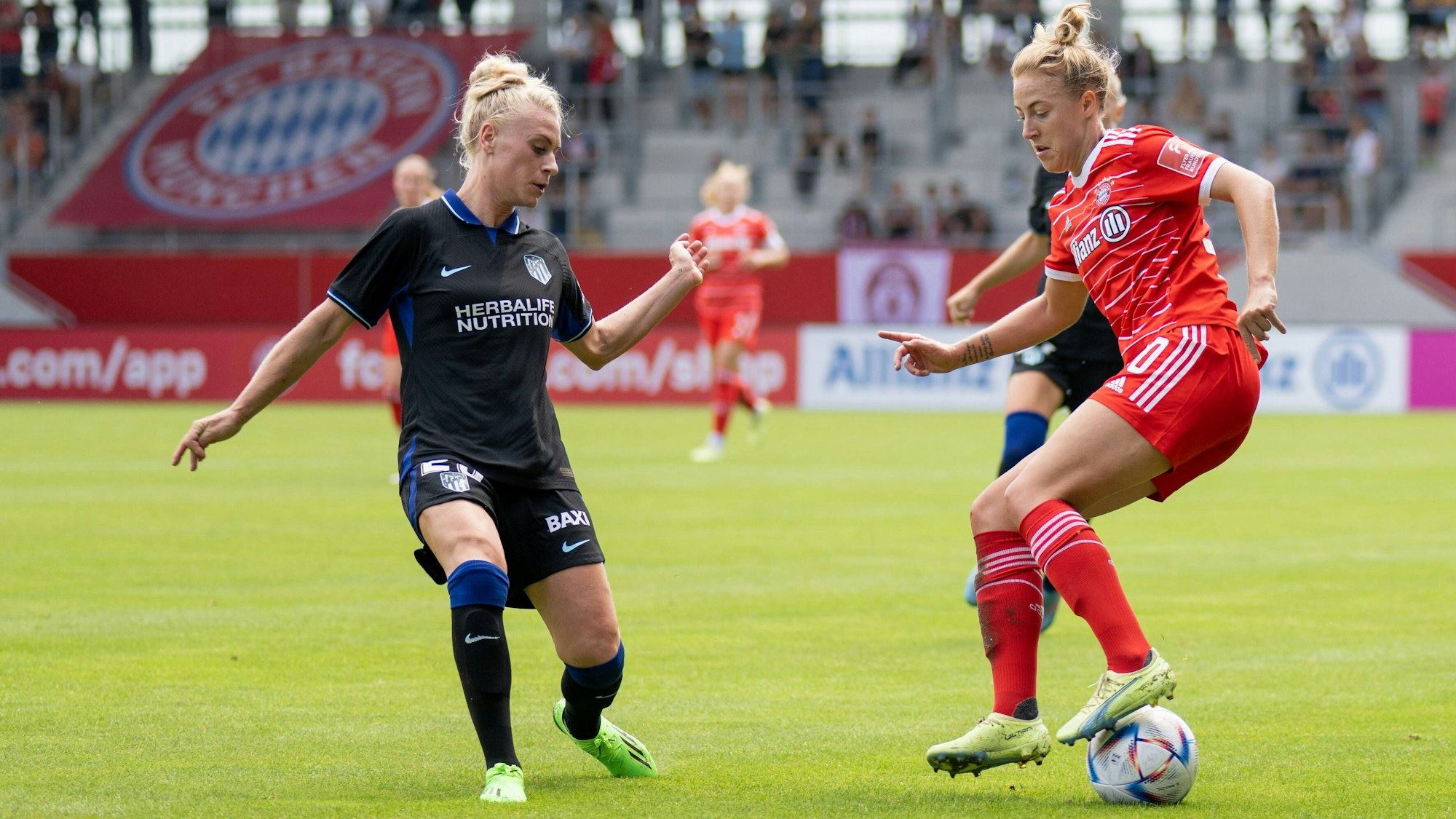 Fußballerin Merle Barth, im Trikot von Atlético Madrid, versucht einer Spielerin vom FC Bayern München, den Ball abzunehmen.