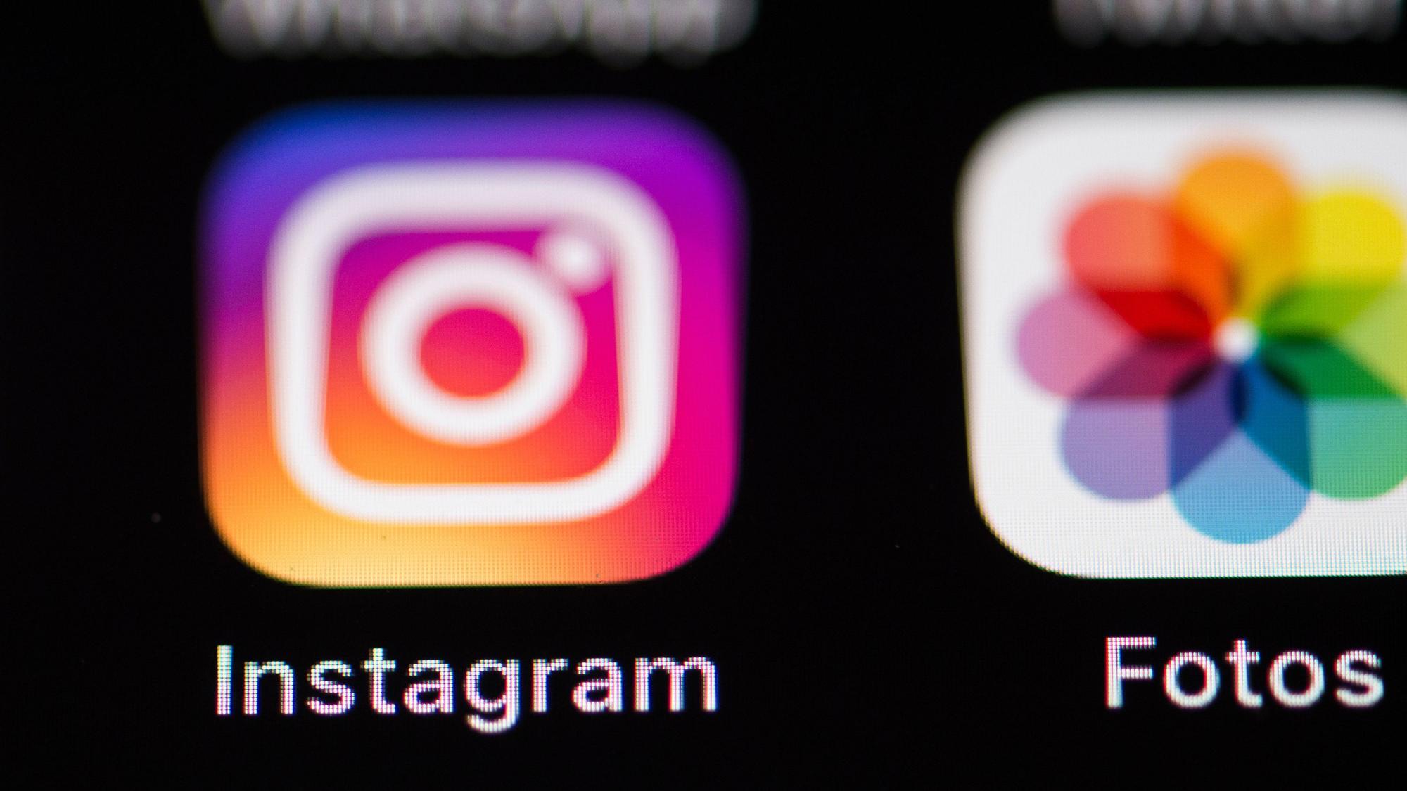 Das Logo des Social-Media-Netzwerks Instagram (l.) ist auf dem Bildschirm eines iPhones zu sehen. (Archivbild)