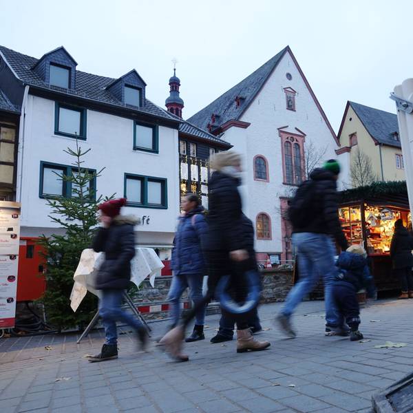 Menschen gehen an einer Absperrbake in Bad Münstereifel vorbei.