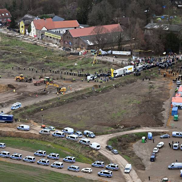Nordrhein-Westfalen, Erkelenz: Polizeiautos und Polizisten stehen vor der Ortschaft Lützerath, die zur Erweiterung des Braunkohletagebaus Garzweiler II abgebaggert werden soll.