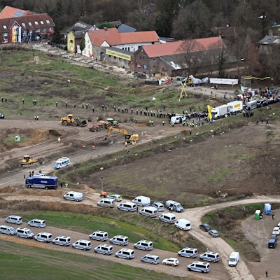 Nordrhein-Westfalen, Erkelenz: Polizeiautos und Polizisten stehen vor der Ortschaft Lützerath, die zur Erweiterung des Braunkohletagebaus Garzweiler II abgebaggert werden soll.