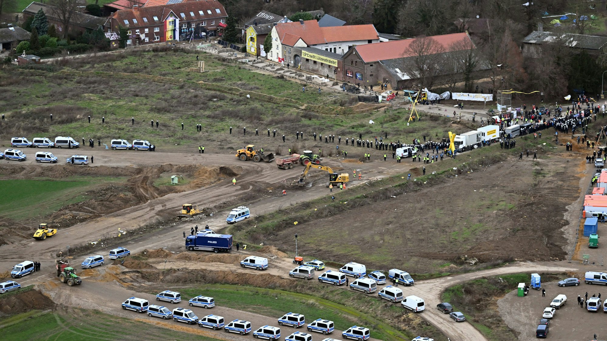 Nordrhein-Westfalen, Erkelenz: Polizeiautos und Polizisten stehen vor der Ortschaft Lützerath, die zur Erweiterung des Braunkohletagebaus Garzweiler II abgebaggert werden soll.