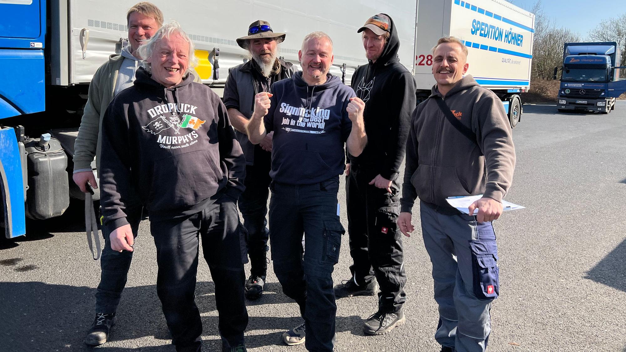 Der Chef der Firma Yellowtools aus Windeck-Wilberhofen, Michael Althof gestartet. steht mit seinem Team im Januar 2023 auf einem Parkplatz vor LKW.