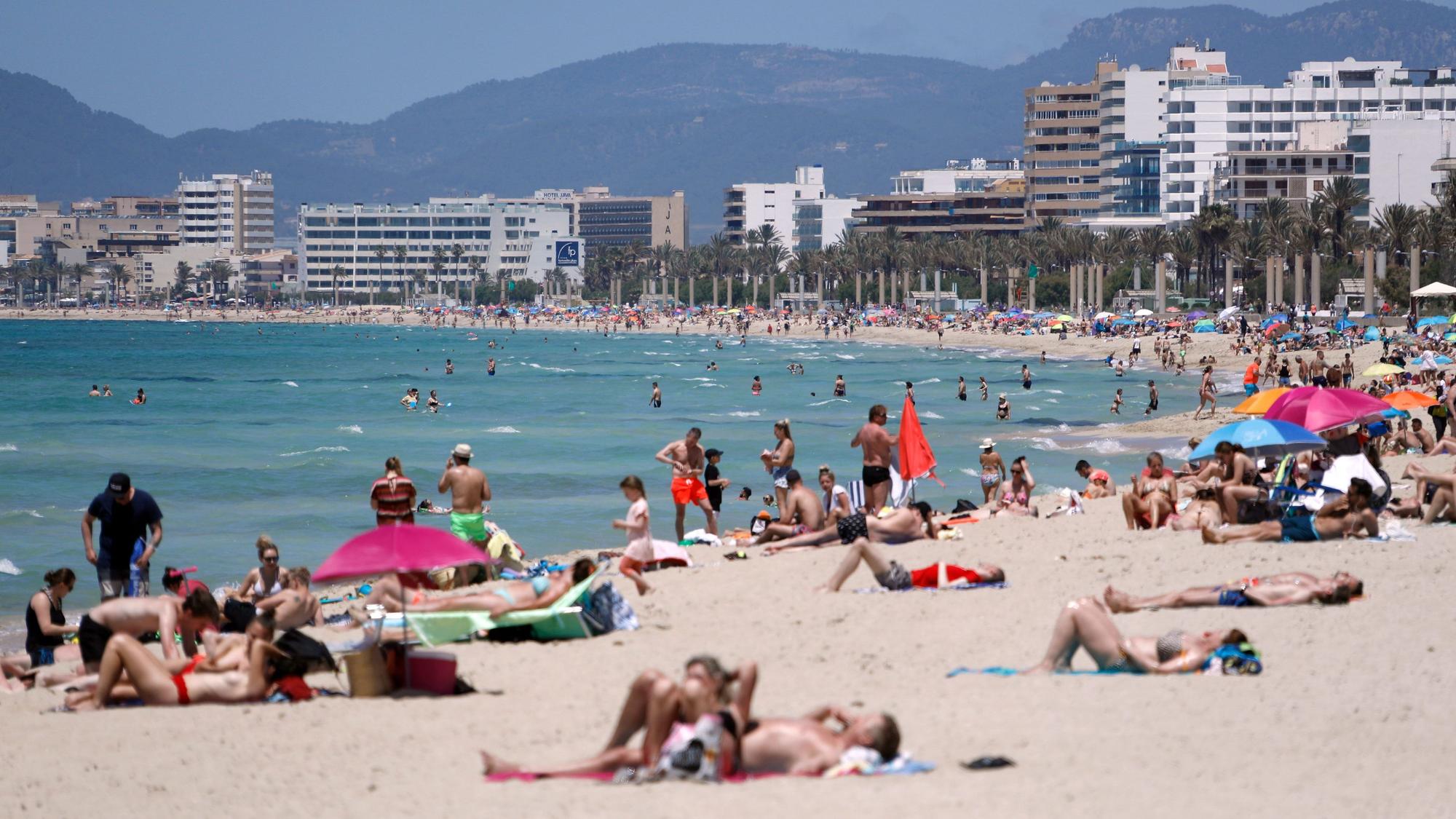 Menschen sonnen sich am Strand von Arenal. An einigen Stränden der Urlaubsinsel Mallorca gilt künftig ein Rauchverbot.