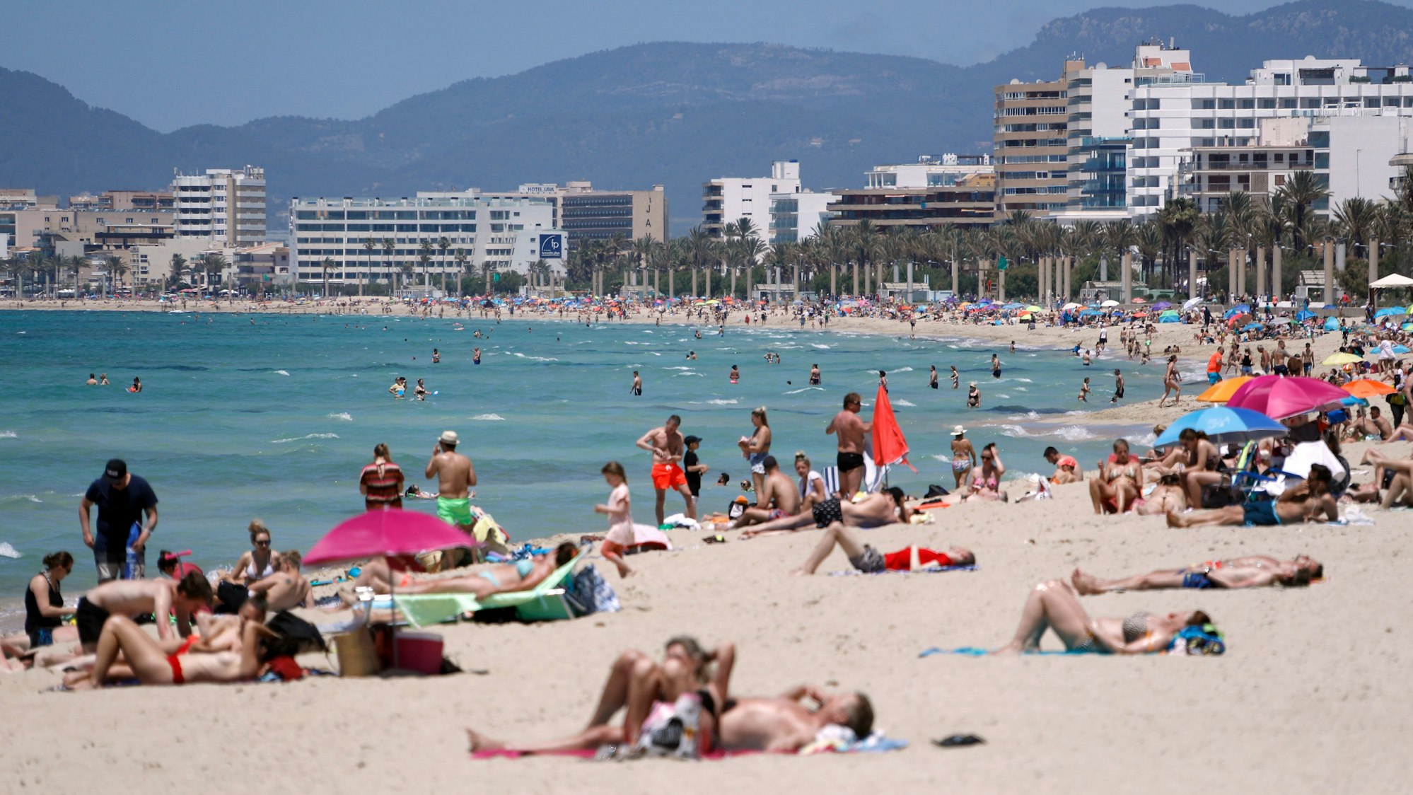 Menschen sonnen sich am Strand von Arenal. An einigen Stränden der Urlaubsinsel Mallorca gilt künftig ein Rauchverbot.