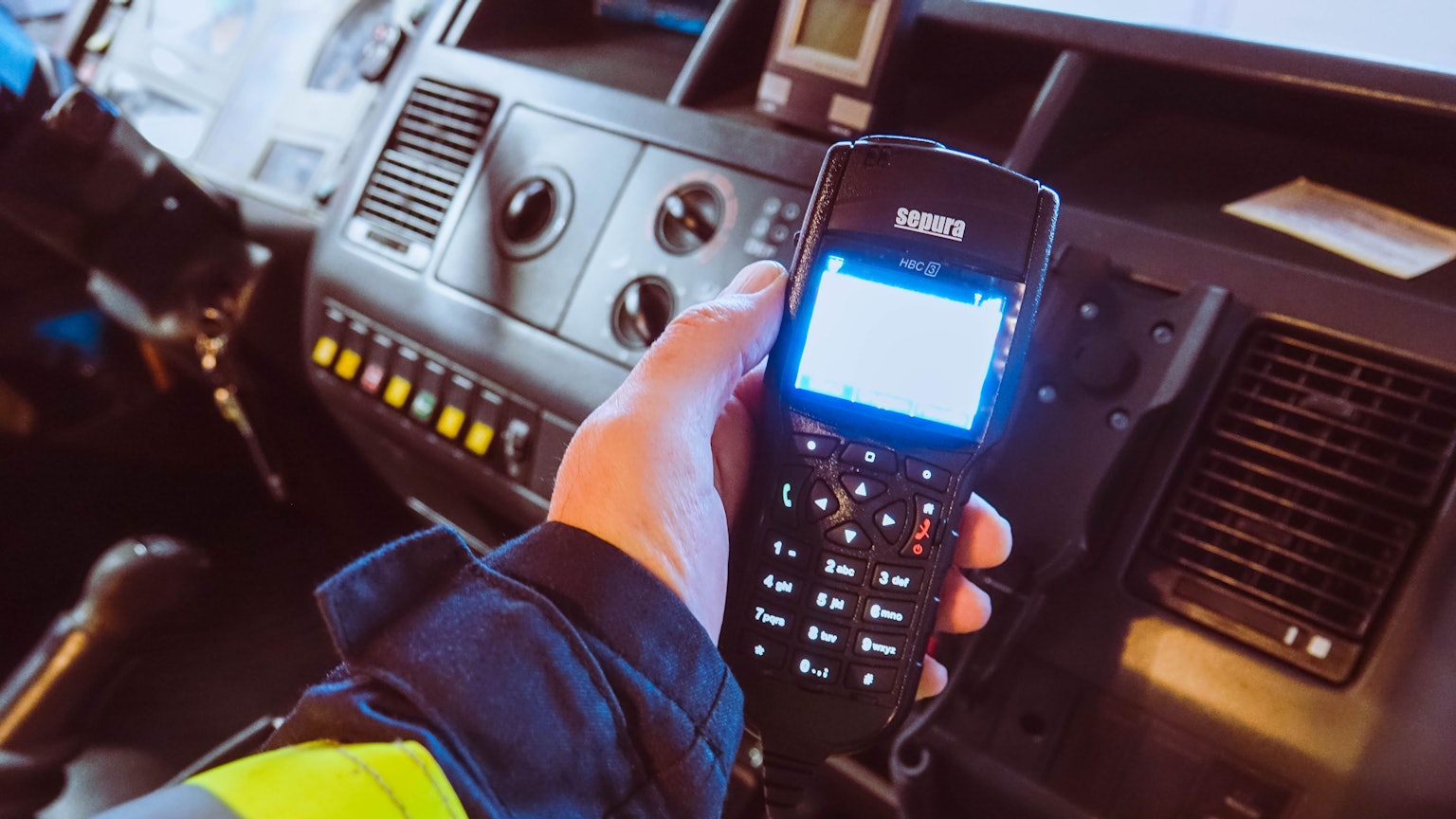 Ein Feuerwehrmann hält ein Digitalfunkgerät in der Hand.