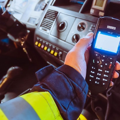Ein Feuerwehrmann hält ein Digitalfunkgerät in der Hand.