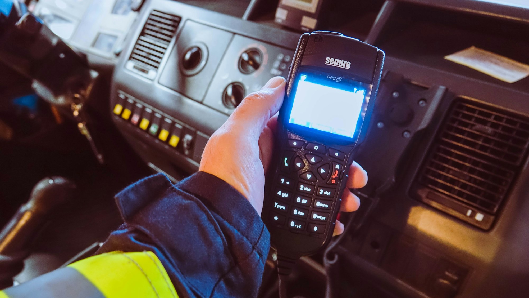Ein Feuerwehrmann hält ein Digitalfunkgerät in der Hand.