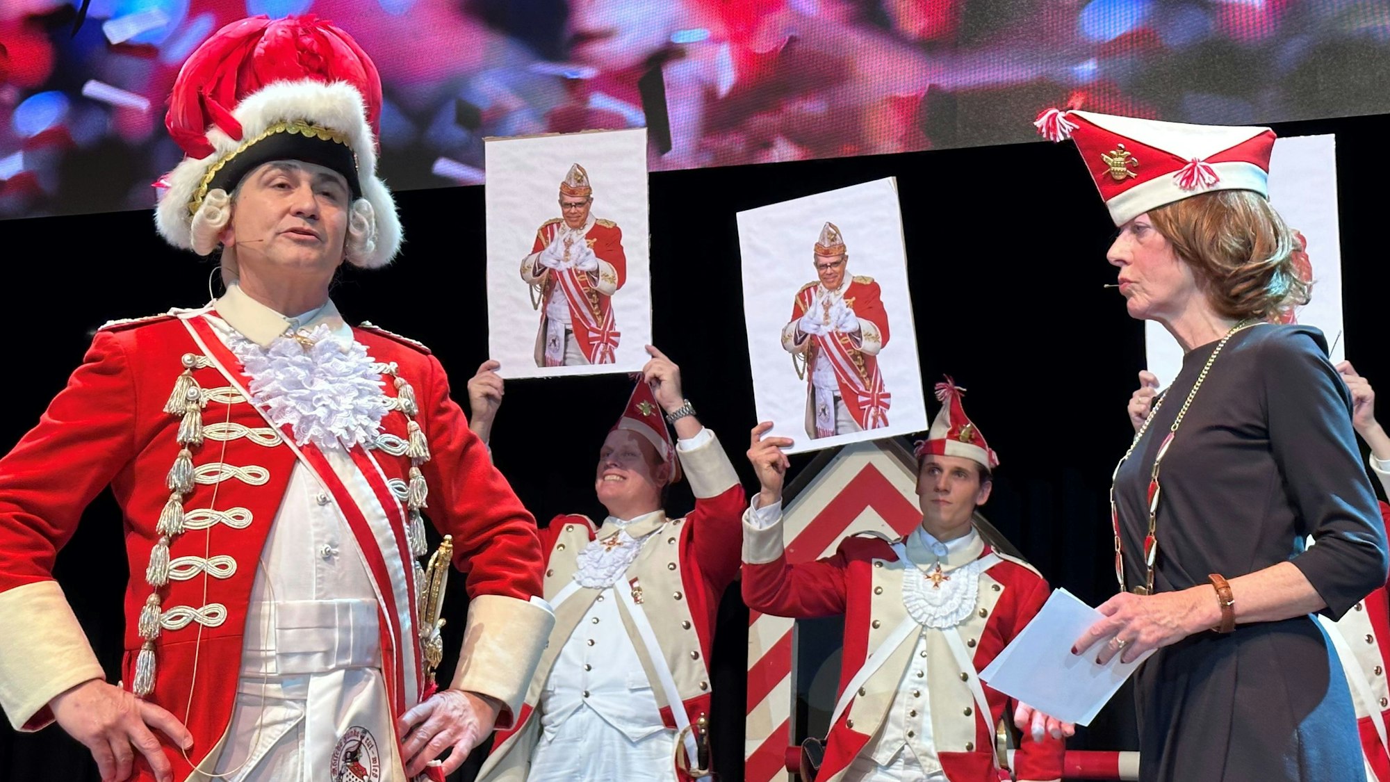 Mehrere Rote Funken in Uniform und eine Frau, die als Henriette Reker verkleidet ist