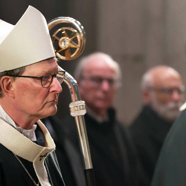 Der Kardinal Rainer Woelki zieht mit weißer Mitra, dem Bischofshut, und Hirtenstab zu einem Gedenkgottesdienst für den verstorbenen Papst Benedikt XVI. in den Kölner Dom ein. Im Hintergrund wird er von Gläubigen beobachtet.