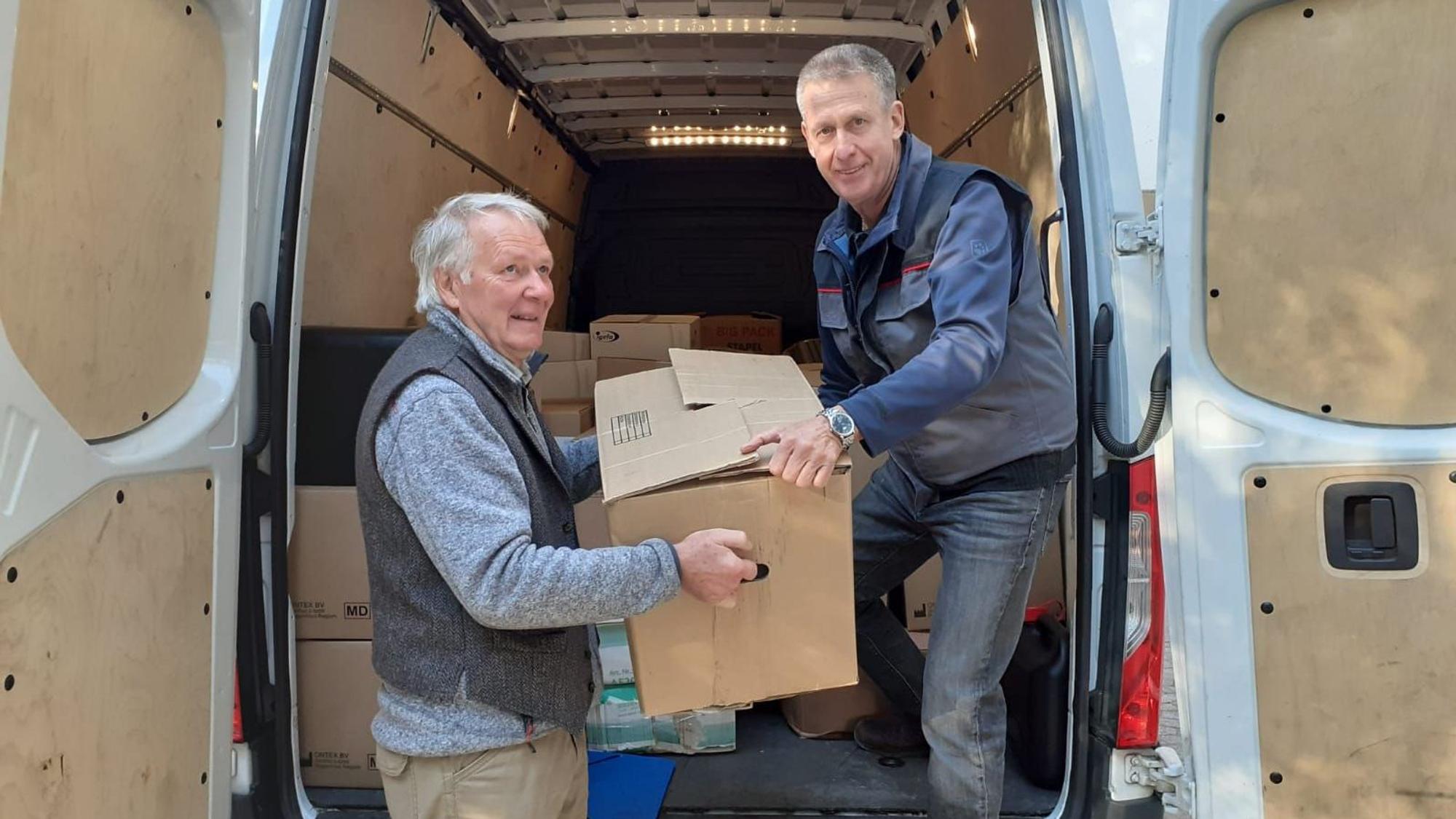 Wilhelm Stein (l.) und Ferdi Schwanitz verladen Kartons in einen Sprinter.