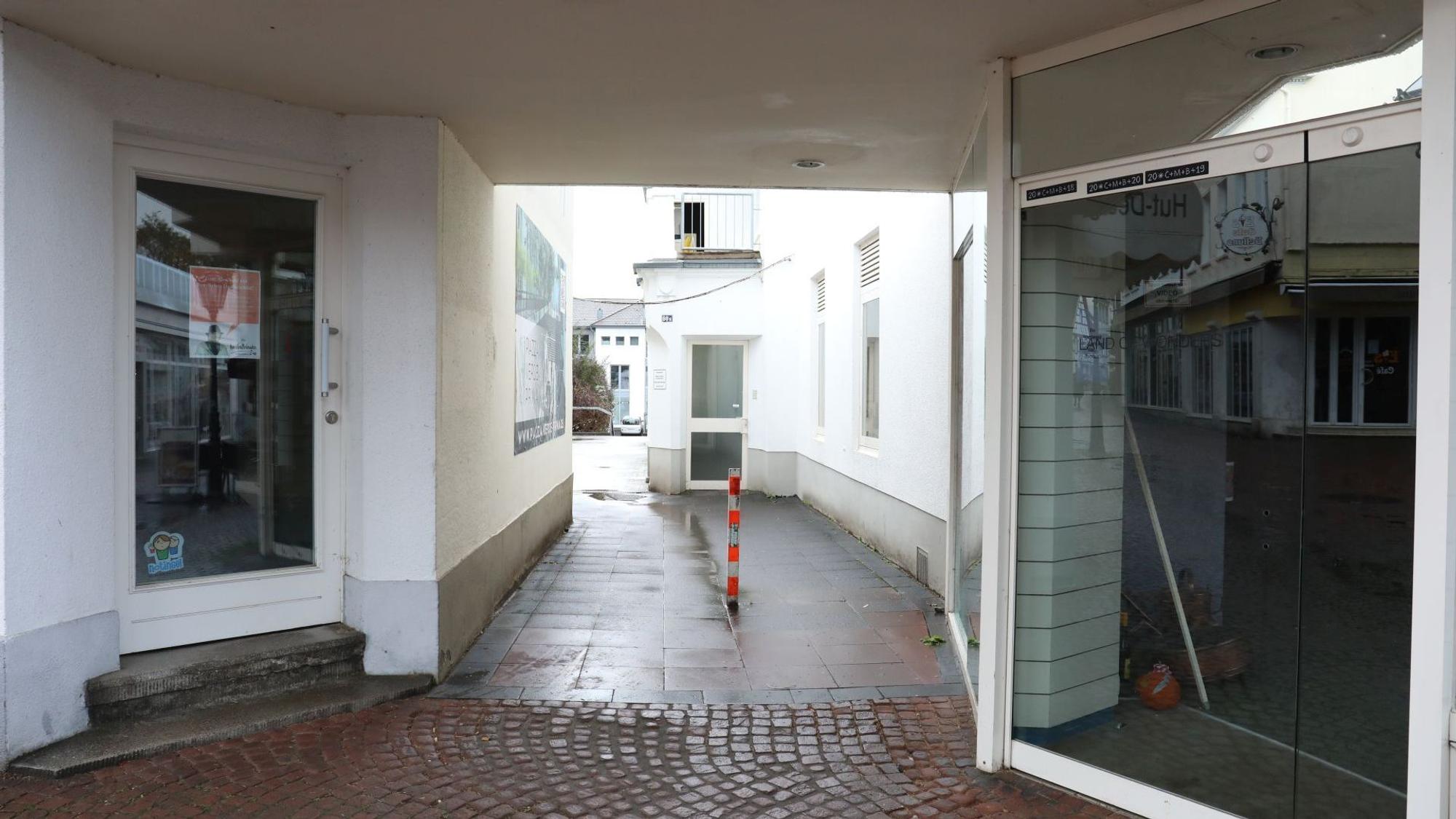 Ein schmaler Gang führt zwischen zwei Ladenlokalen hindurch.