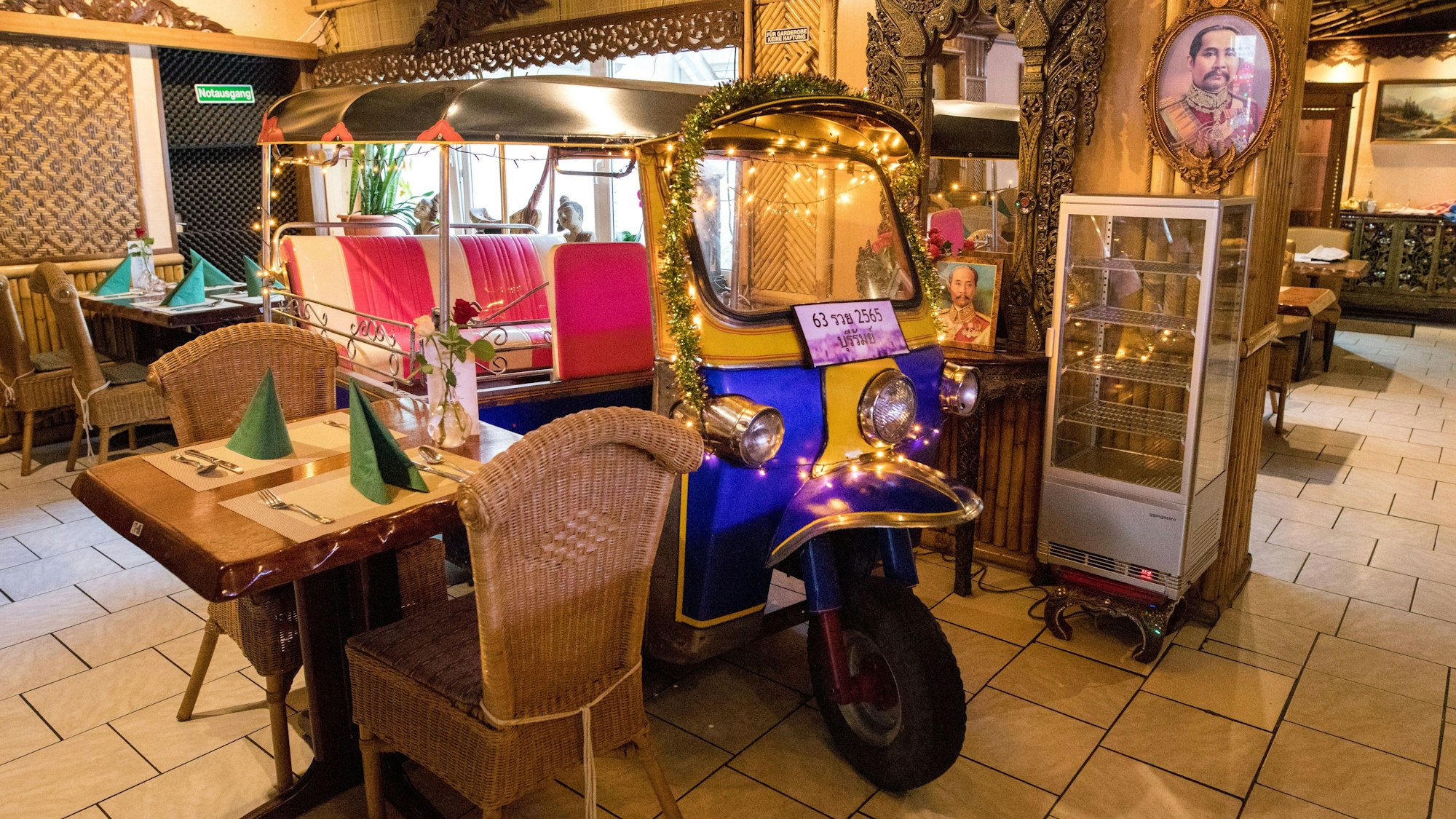 Einrichtung des thailändischen Restaurants Buriram, in der Mitte steht ein mit Lichterketten geschmücktes Tuc Tuc