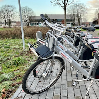 Mehrere Wupsi-Leihräder an der Mobilstation in der Neuen Bahnstadt Opladen, im Hintergrund die Technische Hochschule