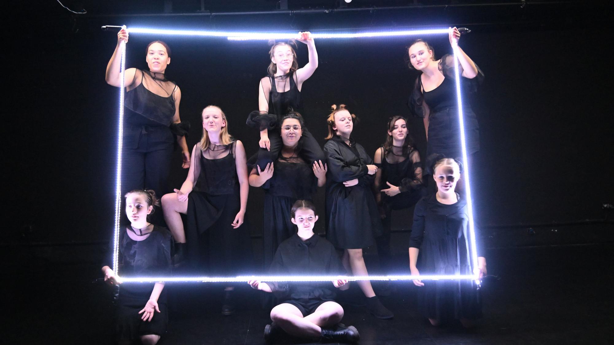 Mitgelider des Jungen Ensemble des Theas-Theaters bei der Produktion „Lichterfangen“, ganz in Schwarz mit Lichtröhren zu einem Quadrat geformt.