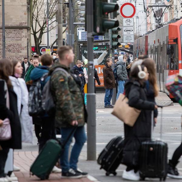 Passanten an einer Straßenbahnhaltestelle