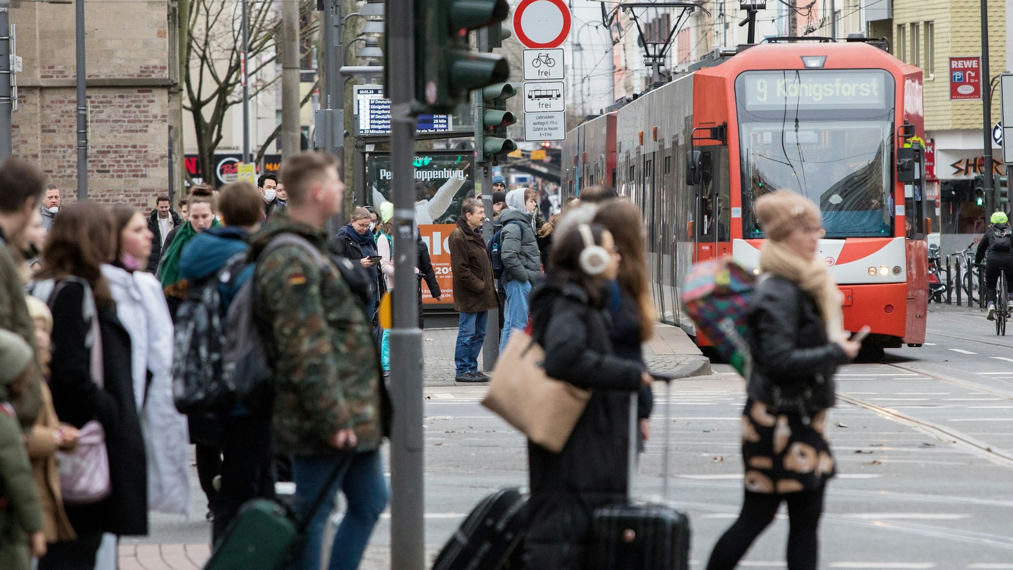 Passanten an einer Straßenbahnhaltestelle