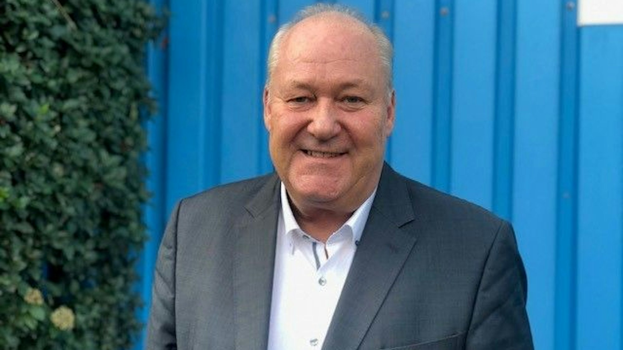 Der Kölner Bauunternehmer Thomas Brauckmann steht vor einem blauen Tor.
