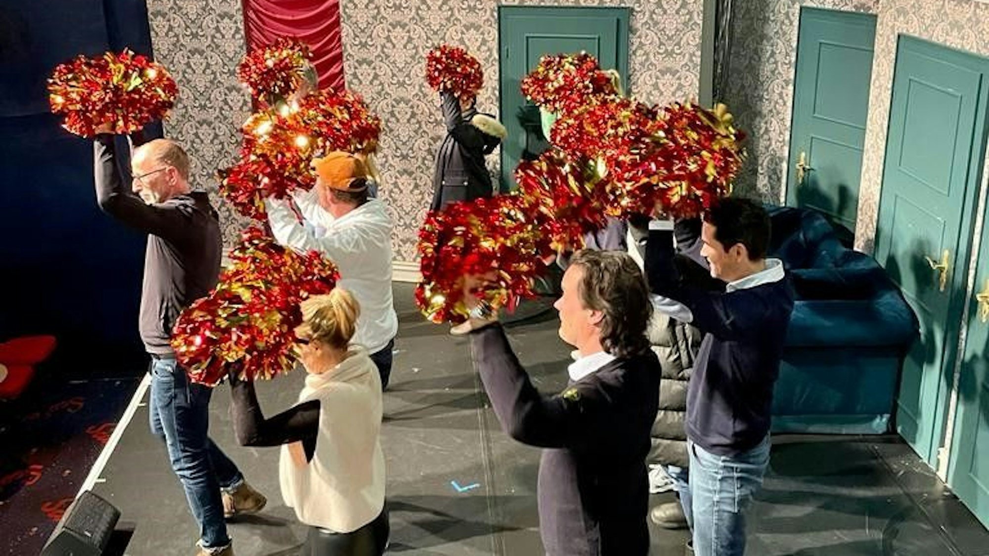 Das Foto zeigt den Elferrat der KG Frohsinn beim Cheerleadertraining auf der Bühne.