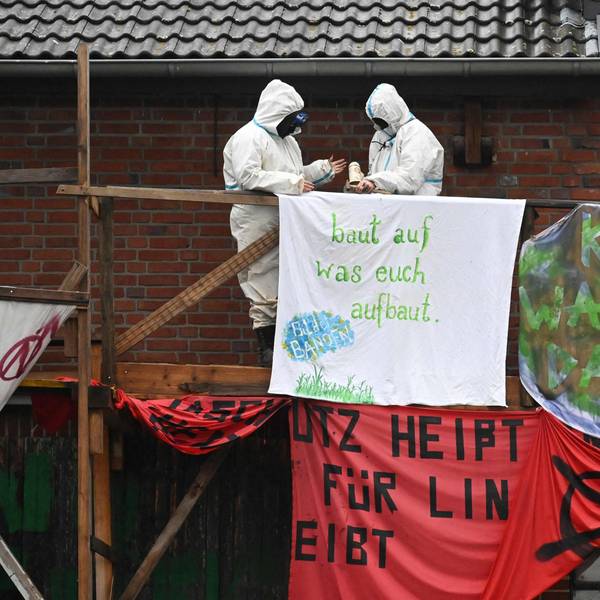 Aktivisten hängen ein Plakat auf, um gegen die Räumung von Lützerath zu protestieren.