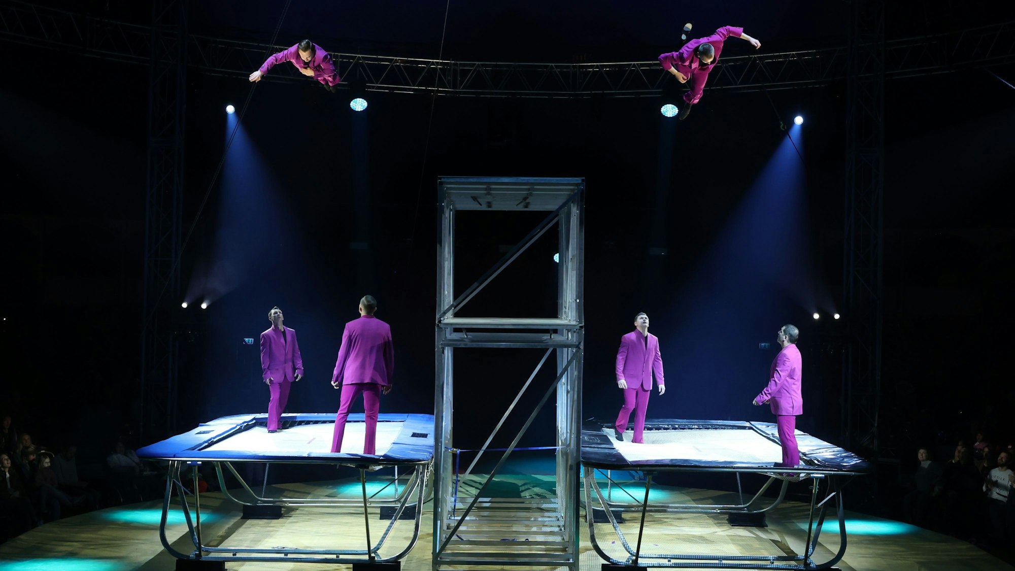 Trampolin-Akrobaten in lila Anzügen