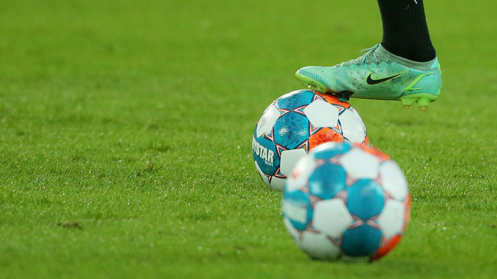 Ein Fußballer ht seinen Fußuf einem Ball.