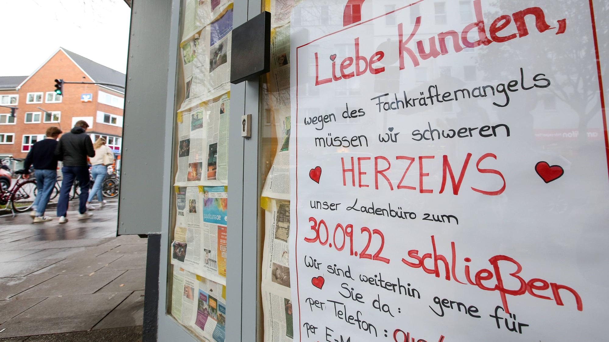 An der Tür eines geschlossenen und mit Zeitungspapier verhängten Ladenbüros eines Reisebüros hängt ein Plakat mit der Aufschrift „Liebe Kunden, wegen des Fachkräftemangels müssen wir schweren Herzens unser Ladenbüro zum 30.09.22 schließen“.