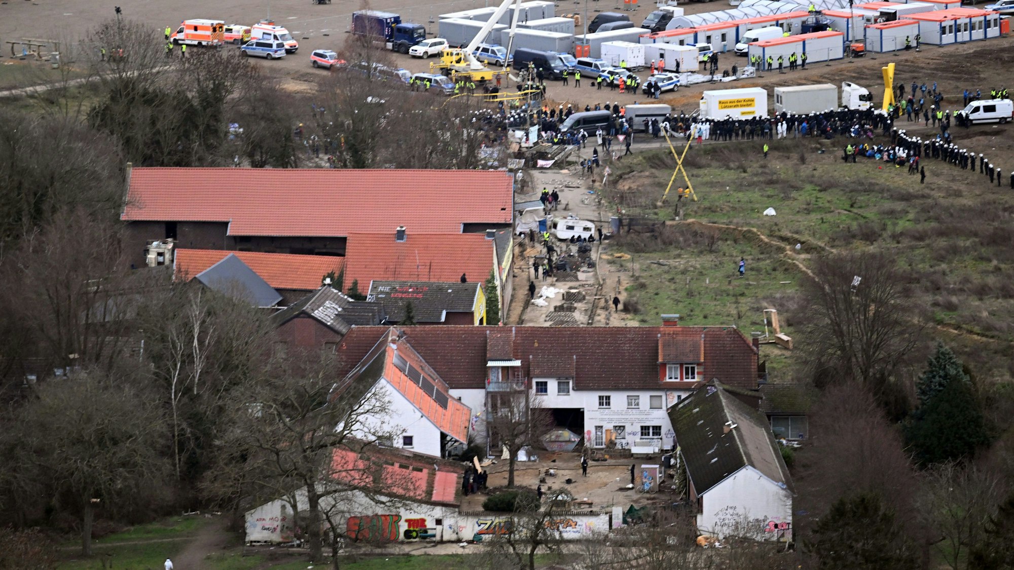 Nordrhein-Westfalen, Erkelenz: Polizeiautos und Polizisten stehen einen Tag vor Beginn der Räumung vor der Ortschaft Lützerath.