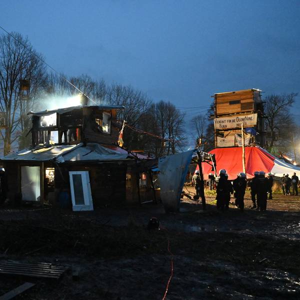 Polizisten stehen bei Räumung im von Klimaaktivisten besetzten Braunkohleort Lützerath vor einer Holzhütte. Unter den Hütten und Barrikaden wurden Tunnel gefunden, die Aktivisten sprachen zuvor von einem Tunnelsystem.