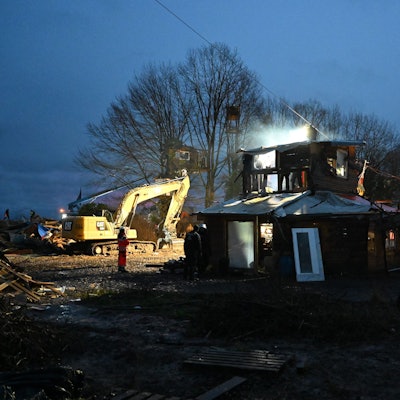 Polizisten stehen bei Räumung im von Klimaaktivisten besetzten Braunkohleort Lützerath vor einer Holzhütte. Unter den Hütten und Barrikaden wurden Tunnel gefunden, die Aktivisten sprachen zuvor von einem Tunnelsystem.