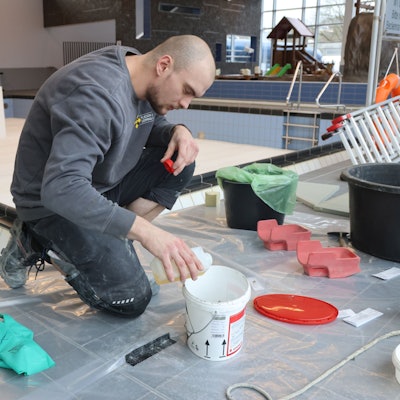Evgeny Krumm mischt Epoxidharzmörtel für die Fliesenfugen.