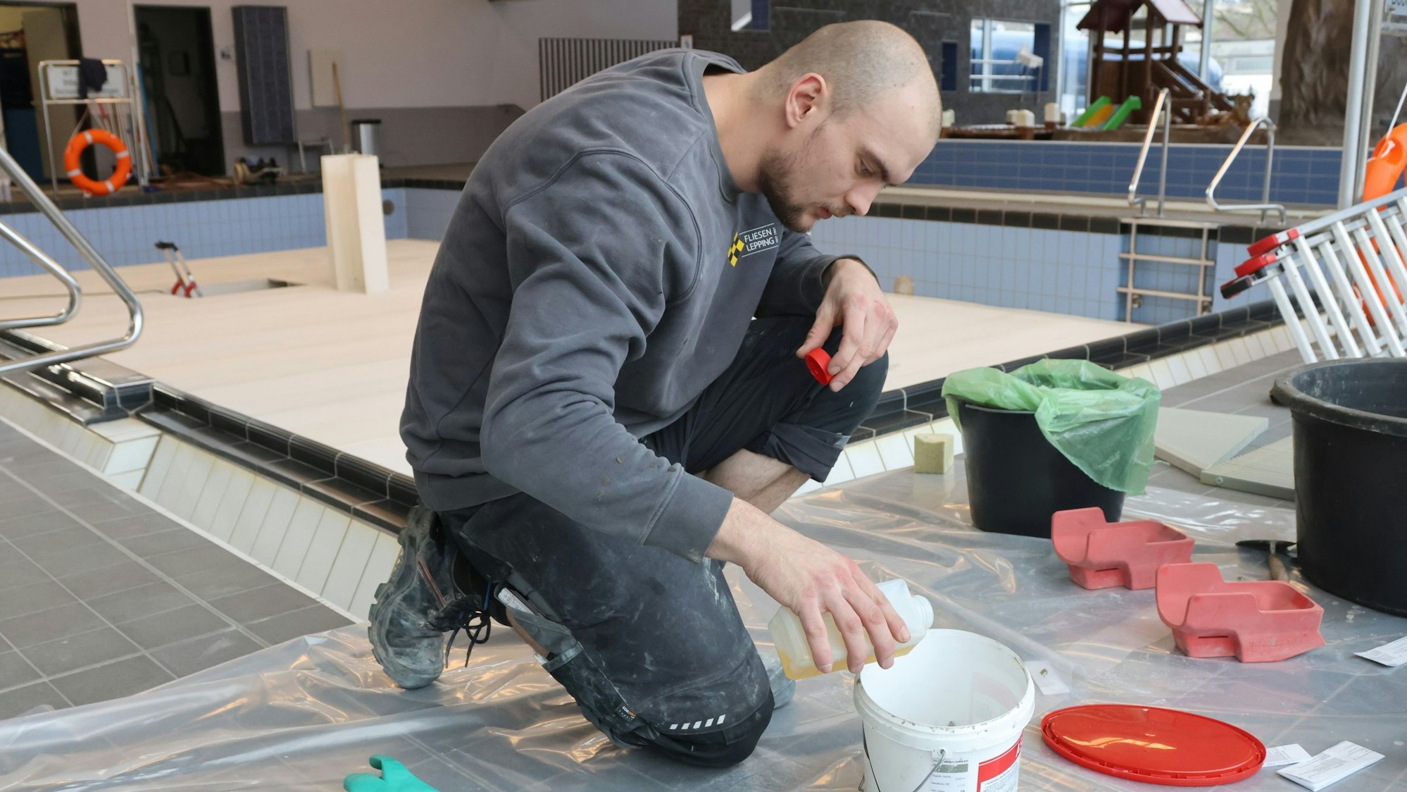 Evgeny Krumm mischt Epoxidharzmörtel für die Fliesenfugen.